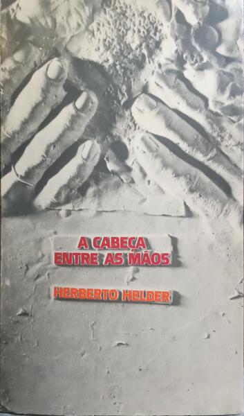 A CABEÇA ENTRE AS MÃOS.